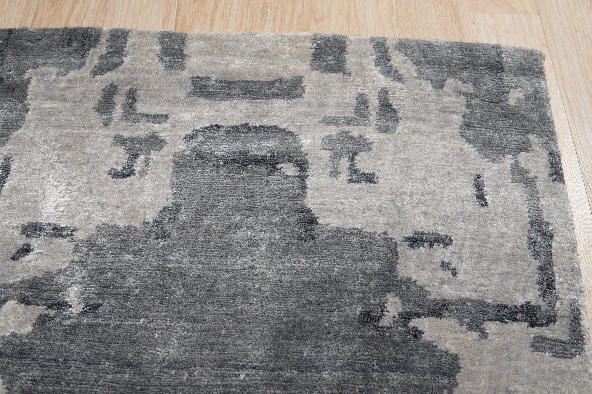 Graceful Classic Gray Hand Knotted Wool & Viscose Rug, its soft gray tones and intricate hand-knotted design complementing a bright, modern living space.