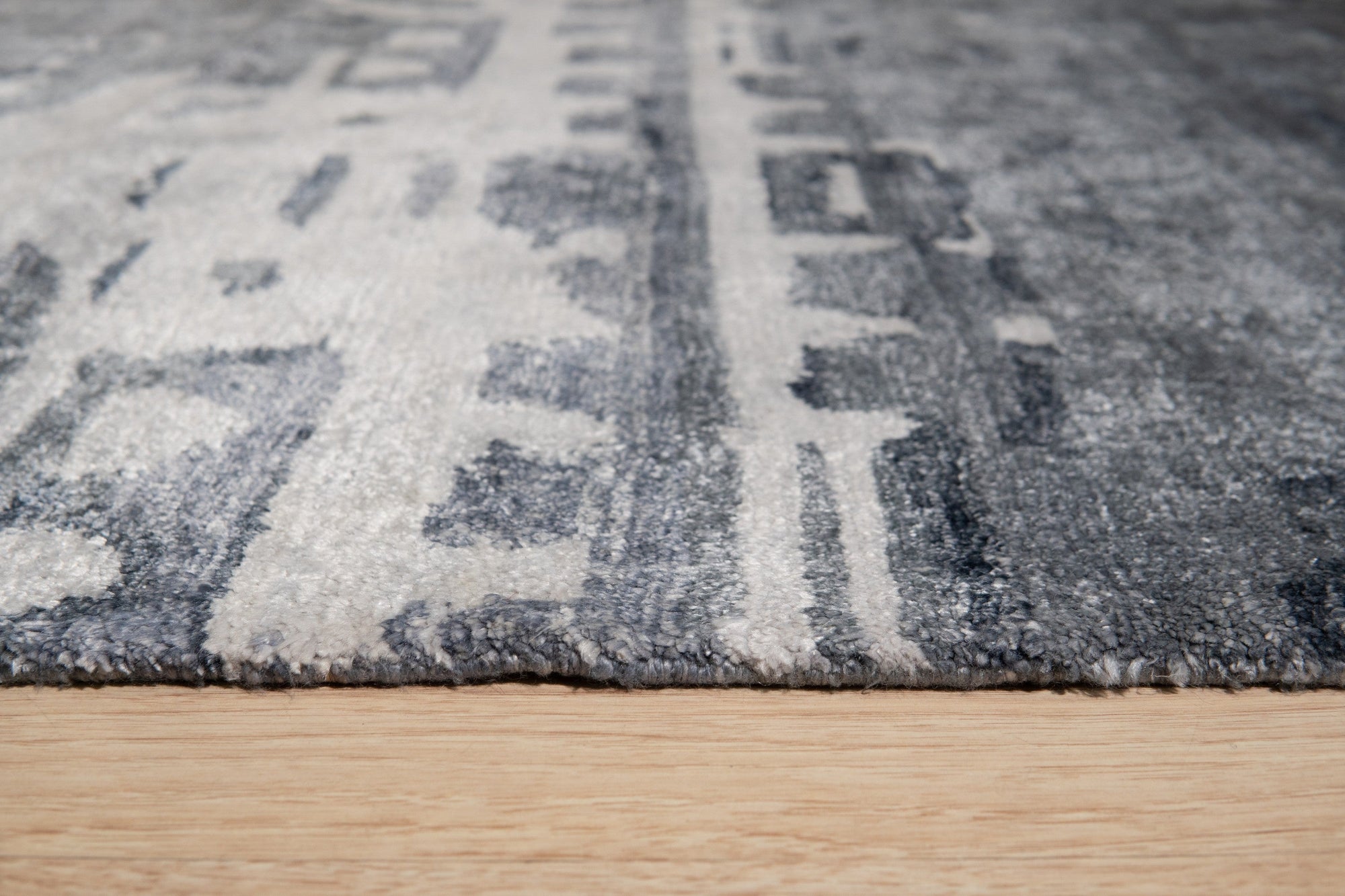 Graceful Classic Gray Hand Knotted Wool & Viscose Rug, a gray rug with a classic design, displayed in a living room setting with neutral furniture.
