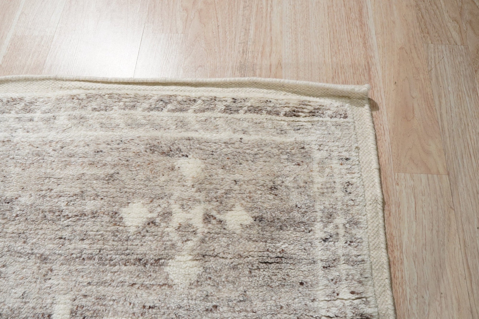 Celia Oushak Gray Hand Knotted Wool Rug, blending muted grays in a traditional Oushak design, graces a sunlit living room, its hand-knotted wool offering inviting texture beneath a coffee table.