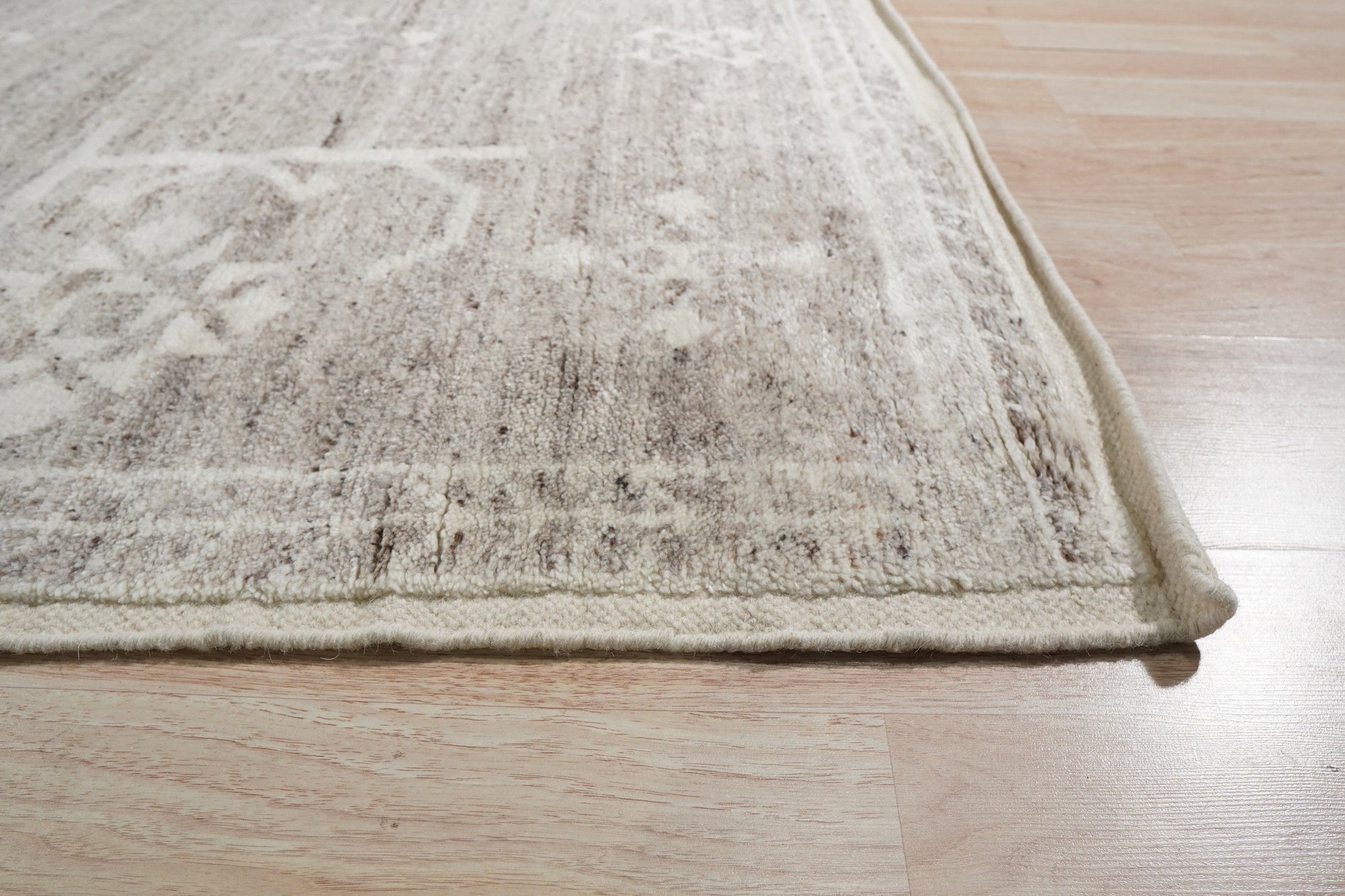 Celia Oushak Gray Hand Knotted Wool Rug, showcasing intricate traditional patterns in soft grays, lies elegantly on a light wood floor, inviting warmth and classic style into the room.