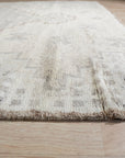 Talia Oushak Ivory Hand Knotted Wool Rug, its intricate floral medallions and soft ivory hues lending warmth to a bright, modern living space with light wood floors.