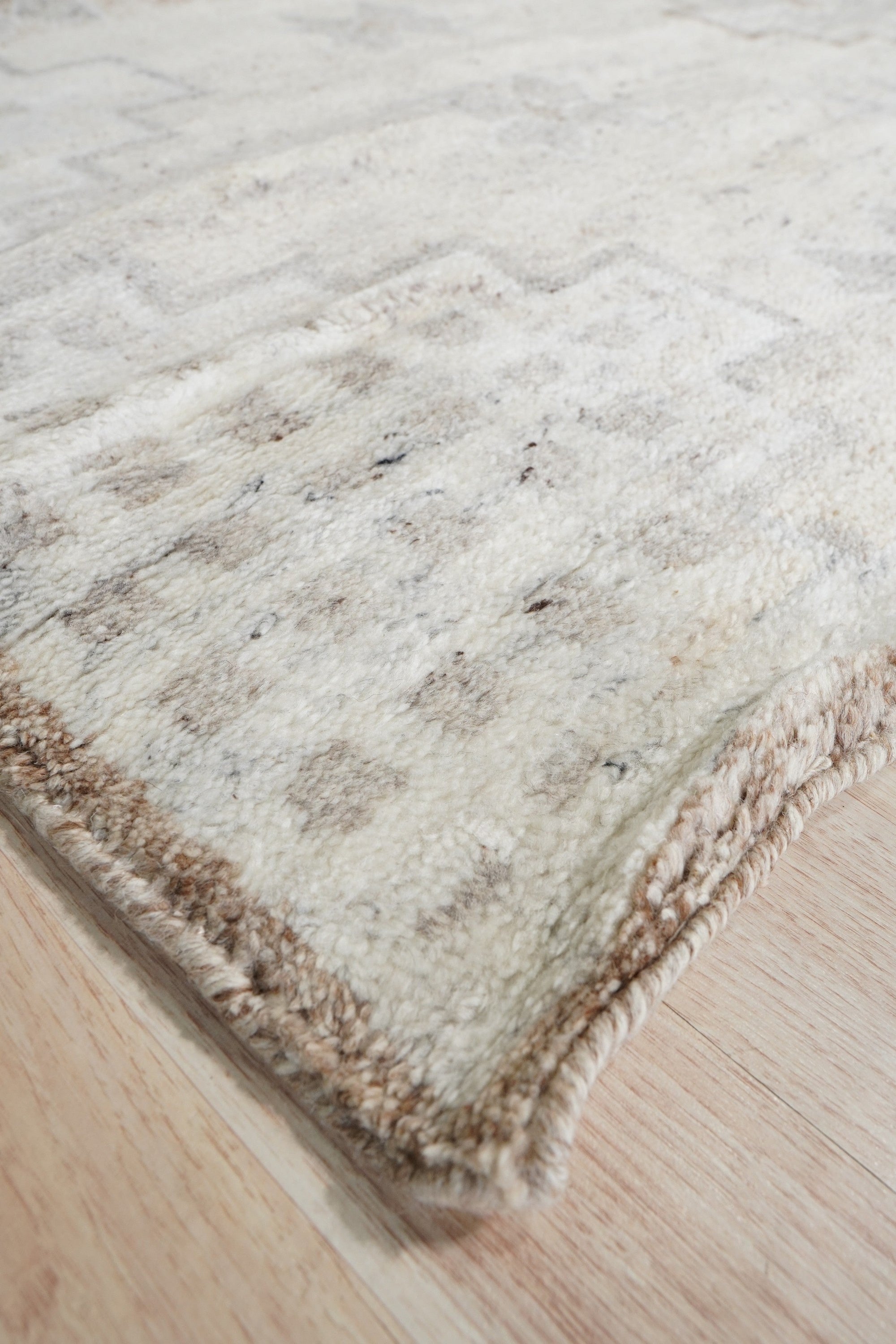Talia Oushak Ivory Hand Knotted Wool Rug, a subtly textured ivory wool rug with a classic Oushak design, lending warmth and understated elegance to a light-filled living space.