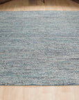 Jade Elegant Blue Hand Knotted Silk Rug, displaying intricate patterns and rich blue hues, laying flat to showcase its luxurious silk texture and hand-knotted construction.