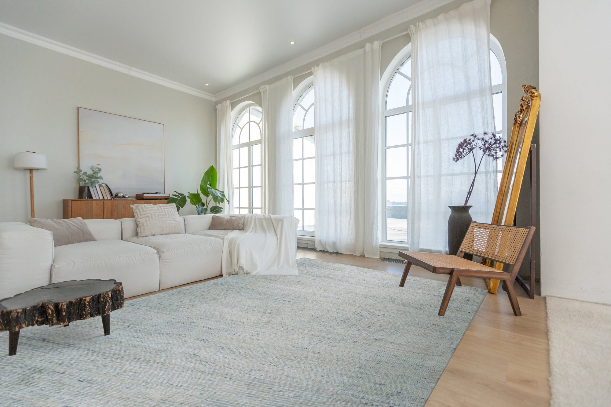 Luna Chloe Green Hand Knotted Silk Rug, its shimmering green silk pile and intricate hand-knotted design accentuating a bright, modern living space with natural light.