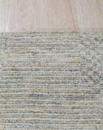 Luna Chloe Green Hand Knotted Silk Rug displayed on a light wood floor. Silk sheen highlights subtle variations in the green and neutral tones of the hand-knotted design.