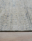 Luna Chloe Green Hand Knotted Silk Rug, shimmering with a soft, muted green hue, displayed in a warmly lit interior setting suggesting sophisticated comfort.