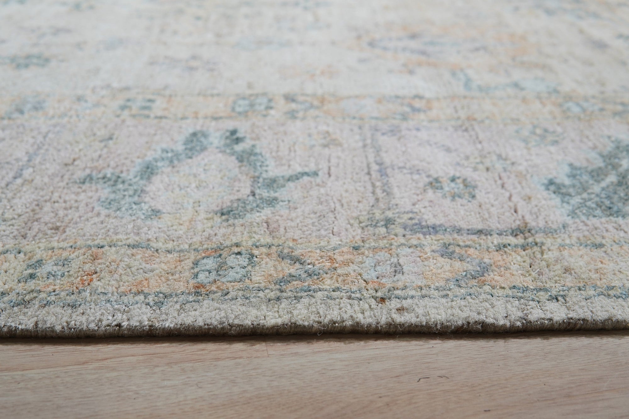 Elena Para Ivory Hand Knotted Silk Rug, softly luminous with intricate patterns, showcased in a living room setting, adding elegance and subtle texture to the space.