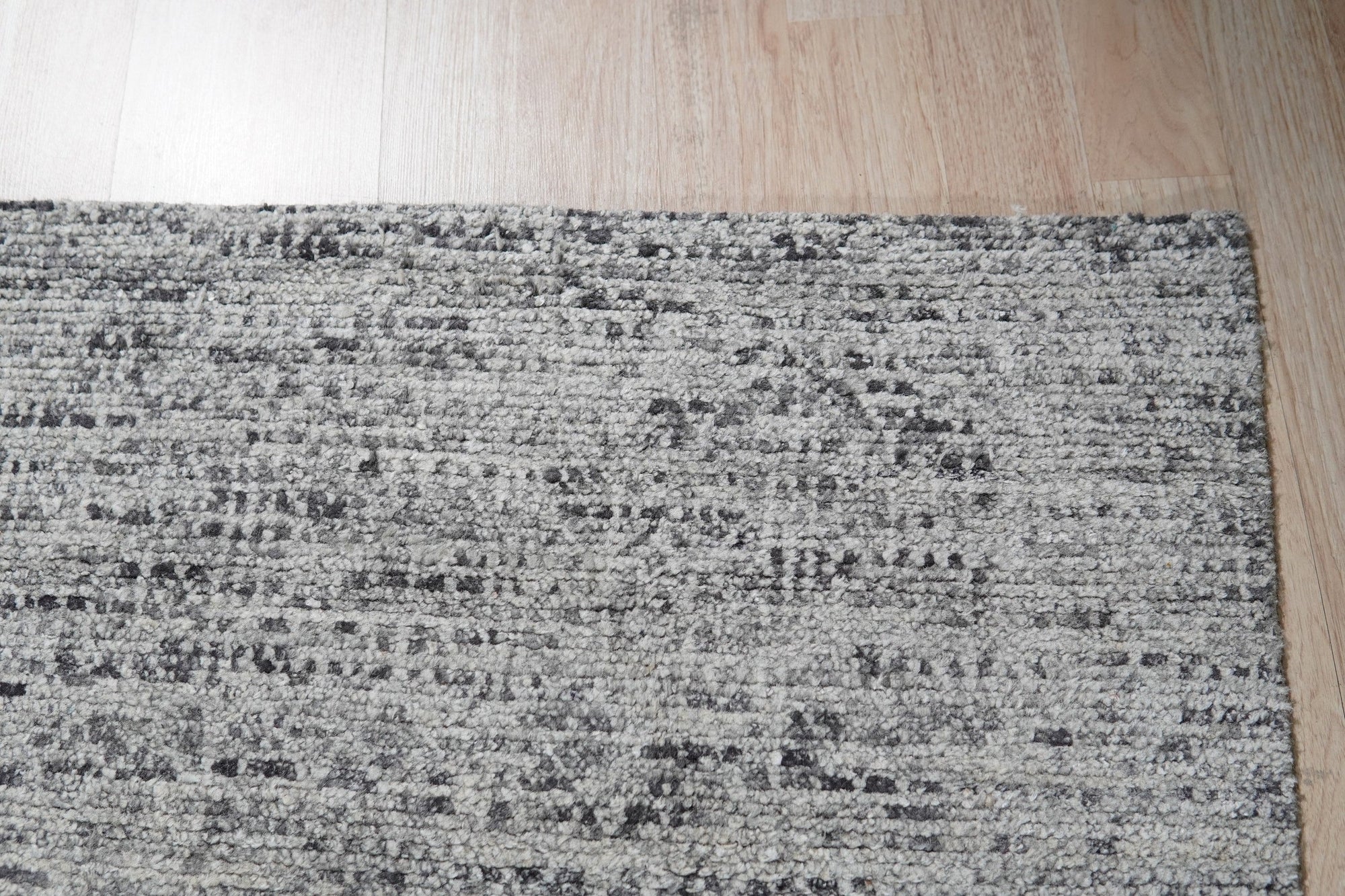 Refined Exquisite Gray Hand Knotted Silk Rug, its subtle sheen and intricate knotting displayed, rests on a hardwood floor, offering a luxurious and elegant texture.