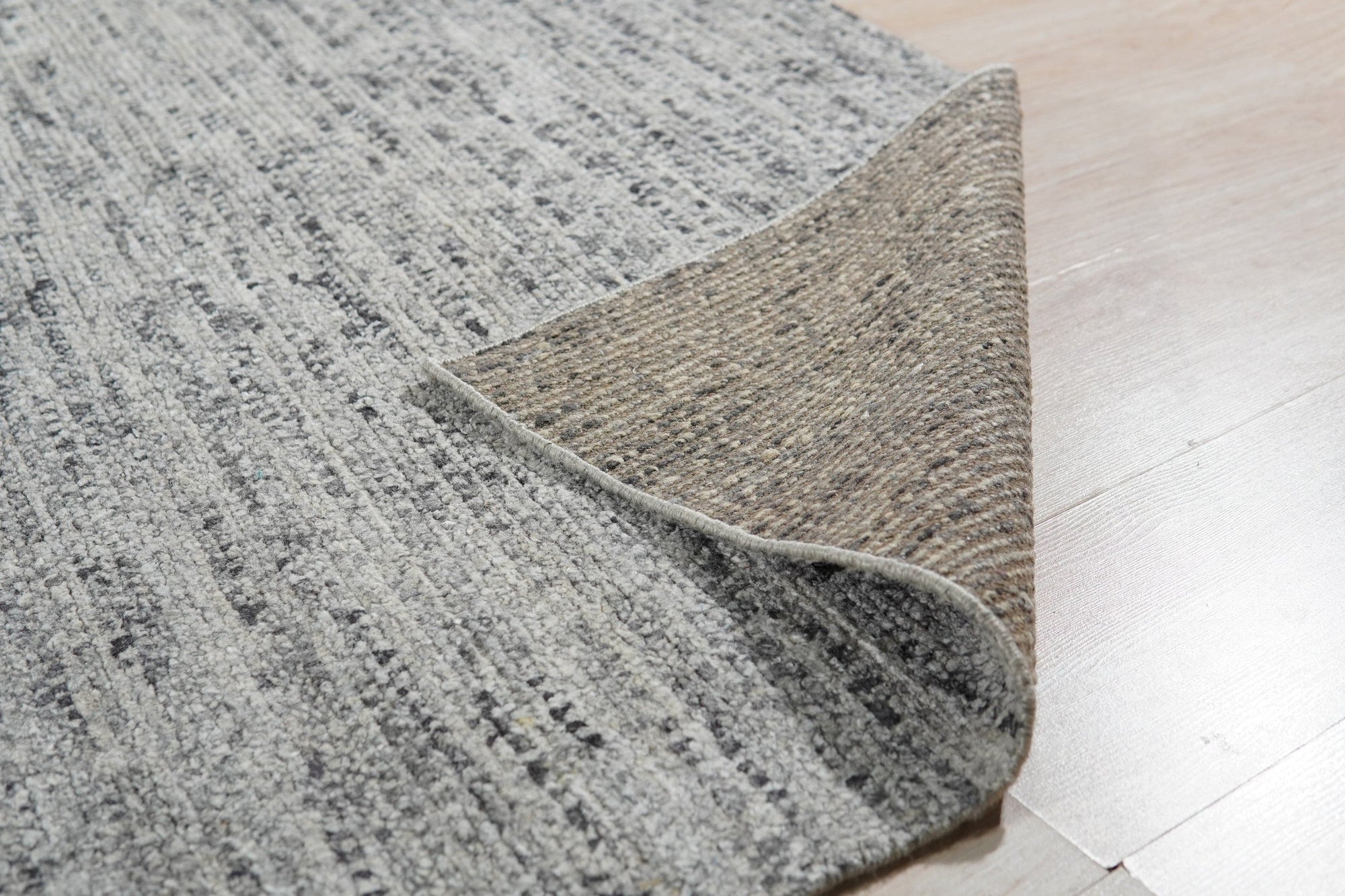 Refined Exquisite Gray Hand Knotted Silk Rug, its shimmering silk pile displayed in a detailed close-up showcasing intricate hand-knotted craftsmanship and subtle tonal variations within the gray color palette.