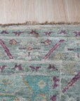 Celia Modern Green Hand Knotted Silk Rug, showcasing its vibrant green hues and luxurious silk sheen, graces a modern interior. Hand-knotted construction evident in its intricate detailing, enhancing the rug's depth and texture within the room.