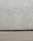Hand-knotted Ruby Fiona Ivory Silk Rug, its luxurious sheen highlighting intricate patterns in warm ivory tones, graces a light-filled room, suggesting understated elegance and timeless design.