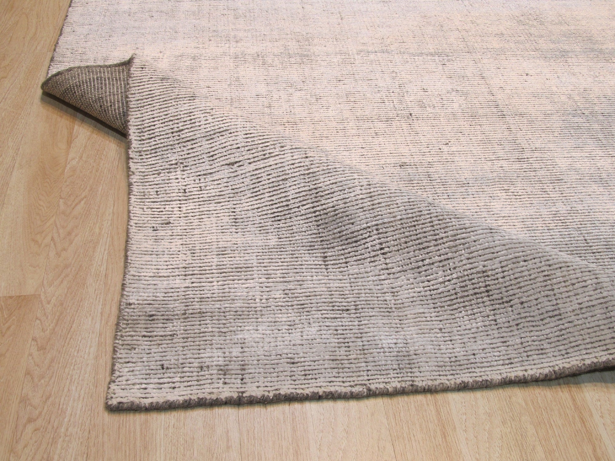 Talia Artisan Gray Handmade Rug, a close-up showcasing the intricate weave and subtle textures of the gray wool, emphasizing its handmade construction.