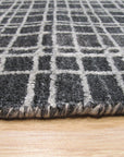 Penelope Isla Gray Handmade Bamboo Silk Rug, its subtle sheen catching the light in a softly lit interior, hints of a complex weave adding depth to the cool gray hues.