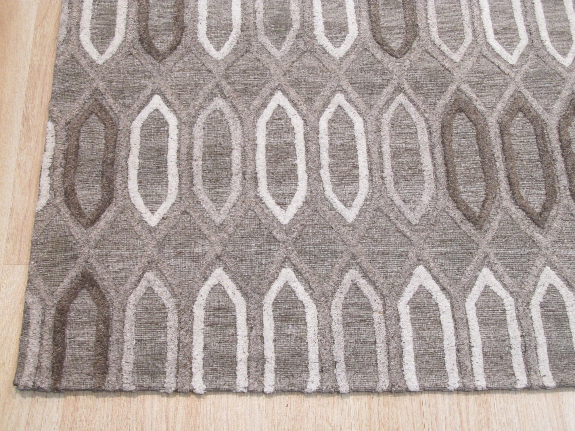 Lila Trellis Gray Nan Rug, a soothing gray rug with a subtle trellis pattern, displayed in a bright, minimalist living space.