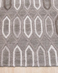 Lila Trellis Gray Nan Rug, a soothing gray rug with a subtle trellis pattern, displayed in a bright, minimalist living space.