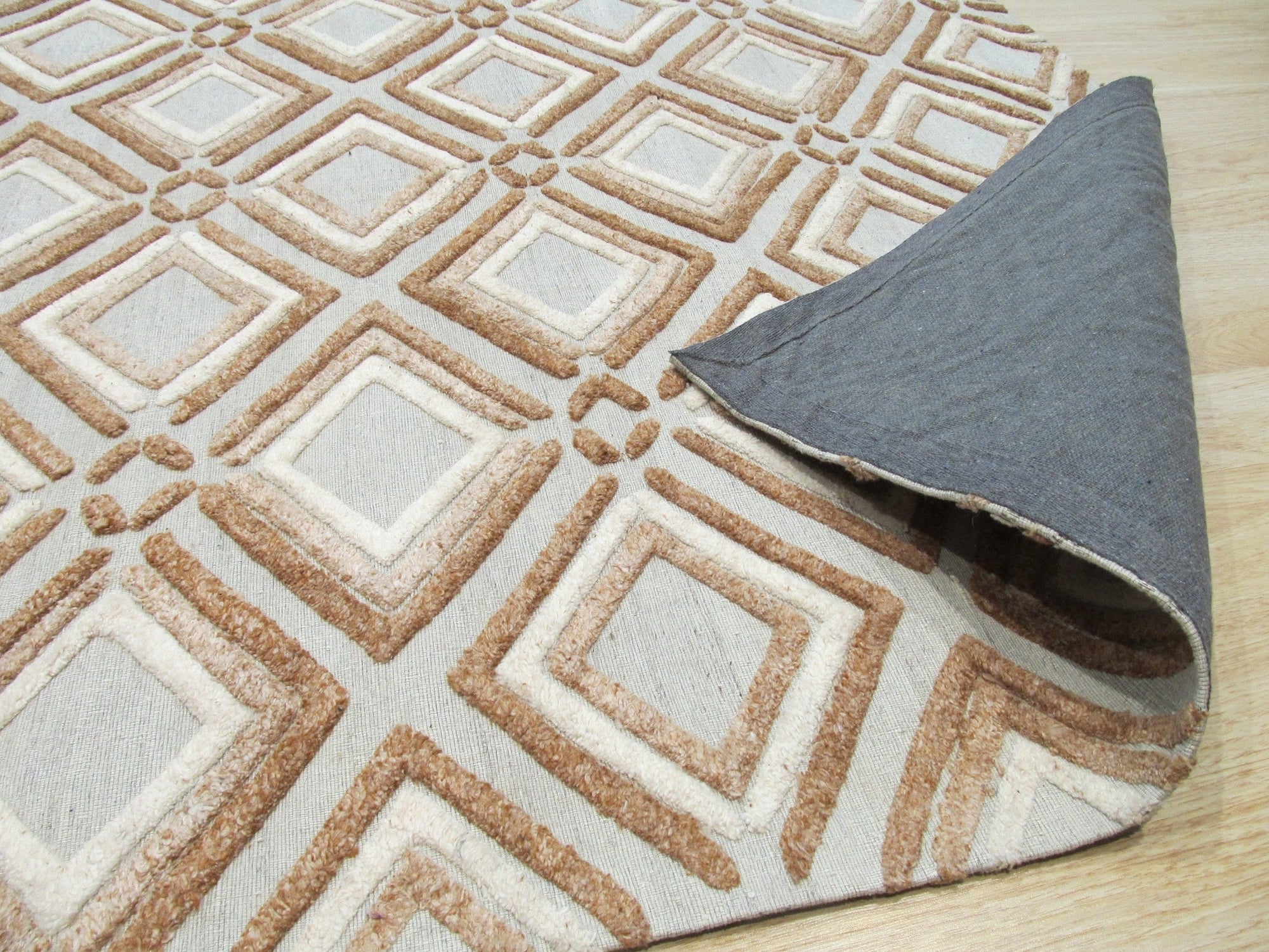 Sumptuous Diamond Brown Hand Knotted Wool Rug, its diamond pattern radiating warmth in a softly lit setting. Hand-knotted wool creates a luxurious texture, grounding the space with its rich brown hues.