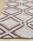 Isla Diamond Purple Hand Knotted Wool Rug, plush wool fibers displaying an intricate diamond pattern in shades of purple and cream, partially visible in a styled interior setting.