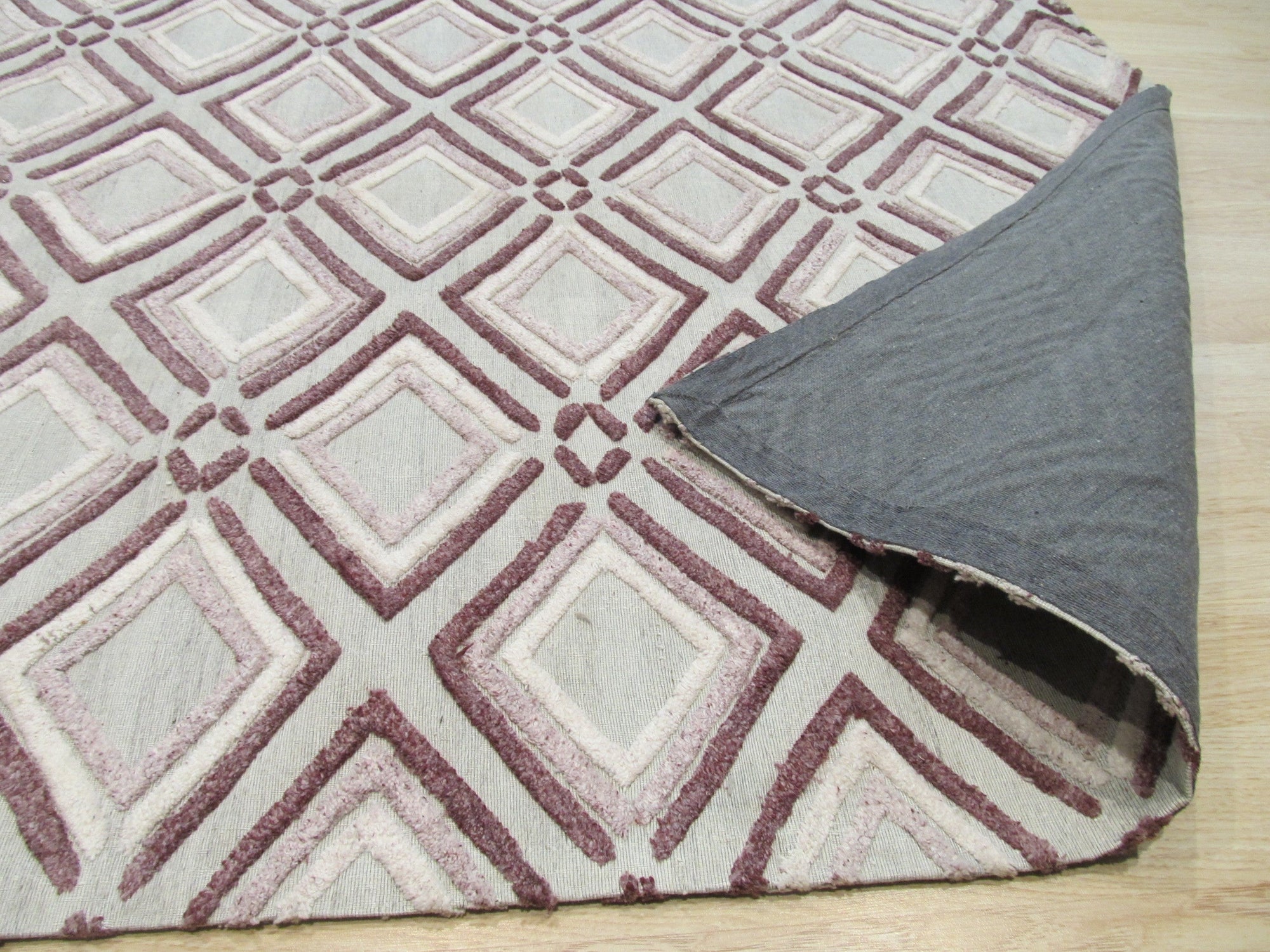 Isla Diamond Purple Hand Knotted Wool Rug displayed with woven texture and diamond pattern detail; plush pile and rich purple hues are prominent in this close-up view.