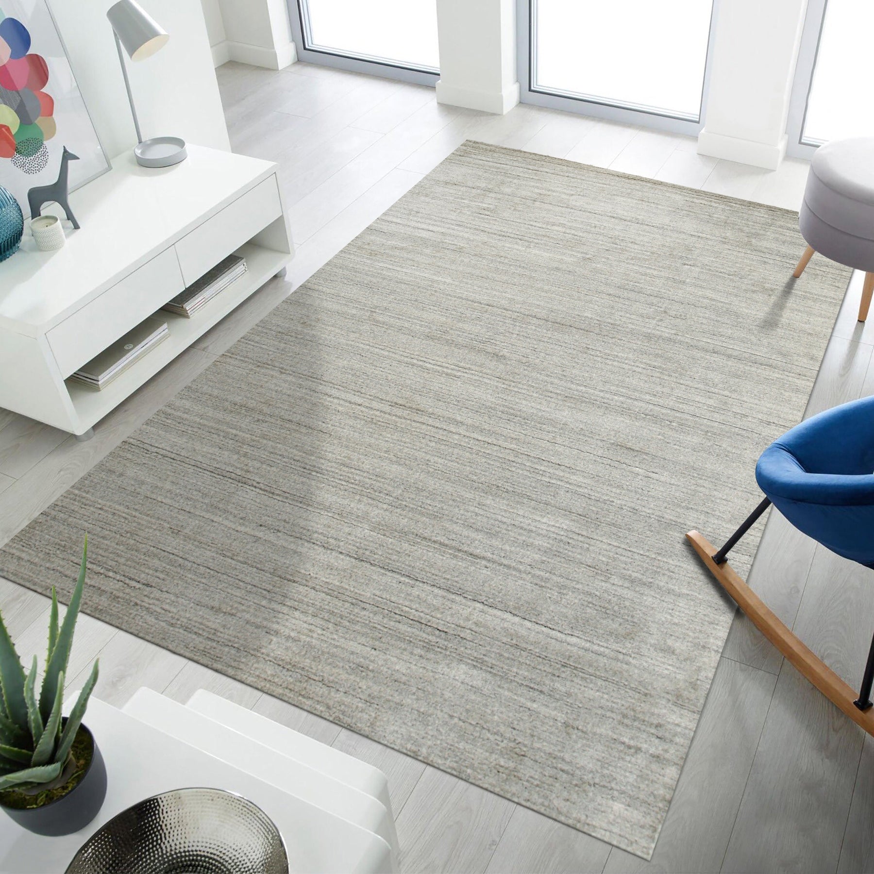 Maya Unique Beige Handmade Wool & Viscose Rug, showcasing soft, natural textures and subtle variations in beige, lies elegantly on a light hardwood floor, hinting at a warm and inviting interior.