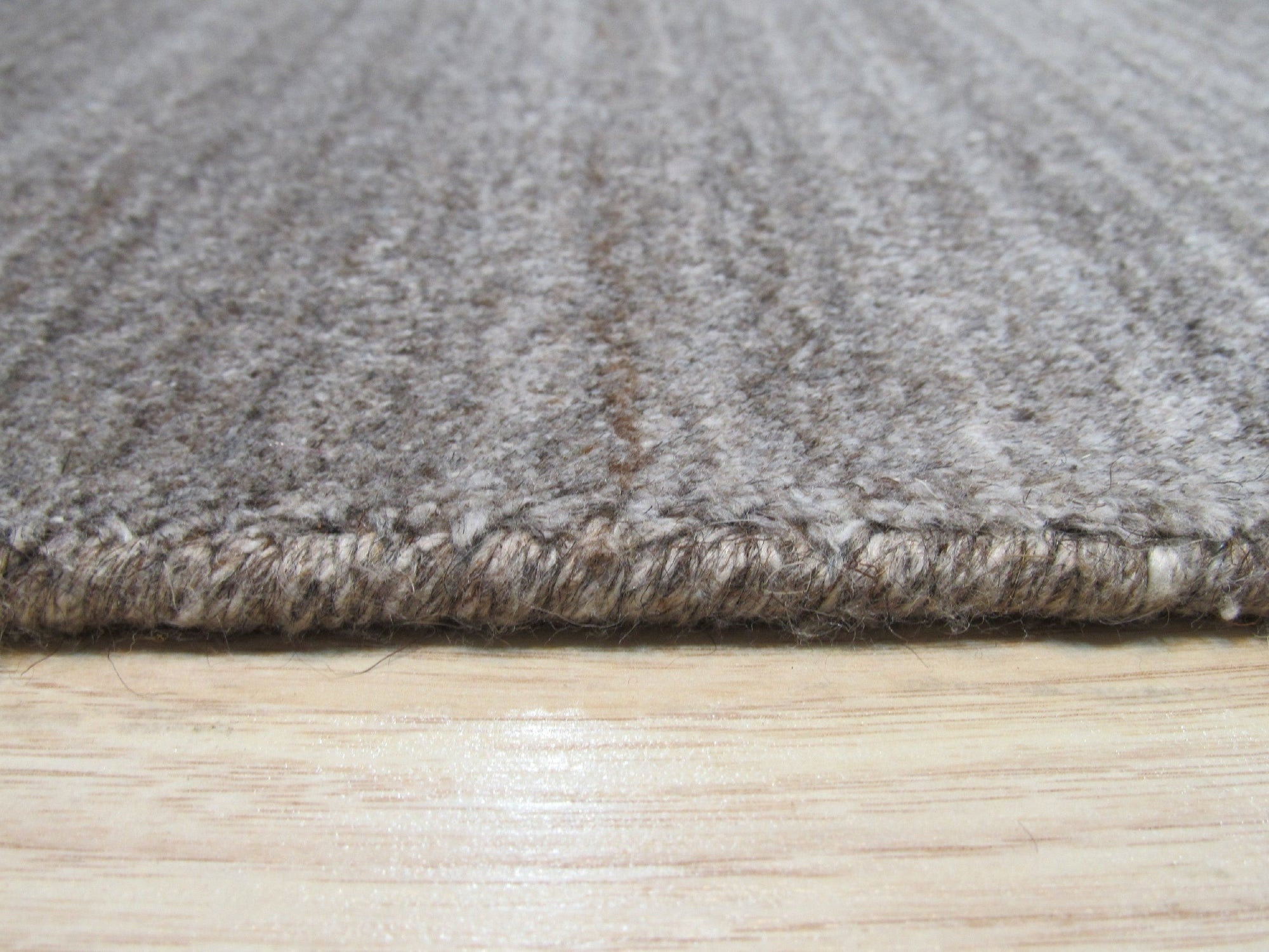 Louie Isla Brown Handmade Wool & Viscose Rug, featuring a subtly patterned design with warm brown tones and shimmering viscose highlights, displayed in a styled living space.