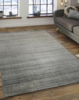 Refined Majestic Silver Handmade Wool & Viscose Rug, showcasing shimmering silver tones and subtle texture variations across a densely woven surface, softly illuminated.