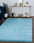Lush Ella Blue Handmade Wool & Viscose Rug, blending cool blues in a textural dance of wool and shimmering viscose fibers, resting elegantly within a bright, modern living space.