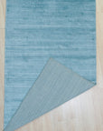 Lush Ella Blue Handmade Wool & Viscose Rug, its cool blue tones and subtle sheen creating a calming presence in a styled living space.