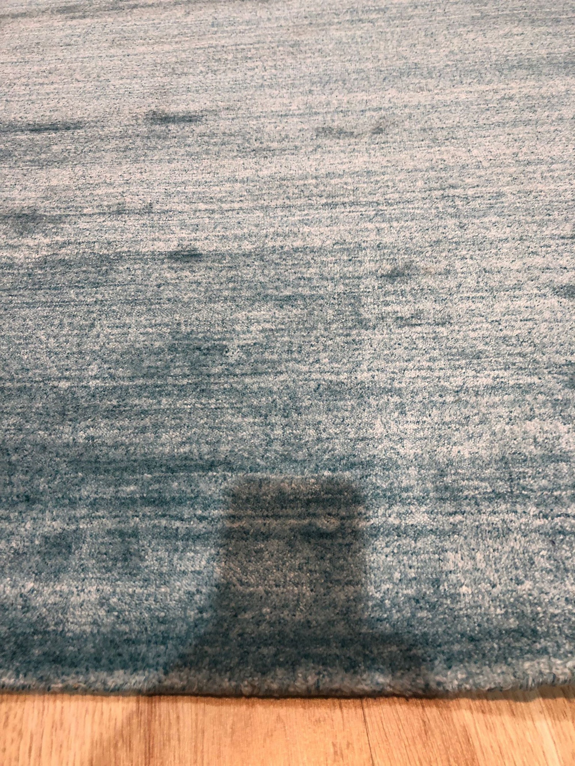 Lush Ella Blue Handmade Wool & Viscose Rug, presenting a calming blend of blues and soft sheen, handwoven construction visible within a bright, airy room.