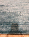 Lush Ella Blue Handmade Wool & Viscose Rug, presenting a calming blend of blues and soft sheen, handwoven construction visible within a bright, airy room.