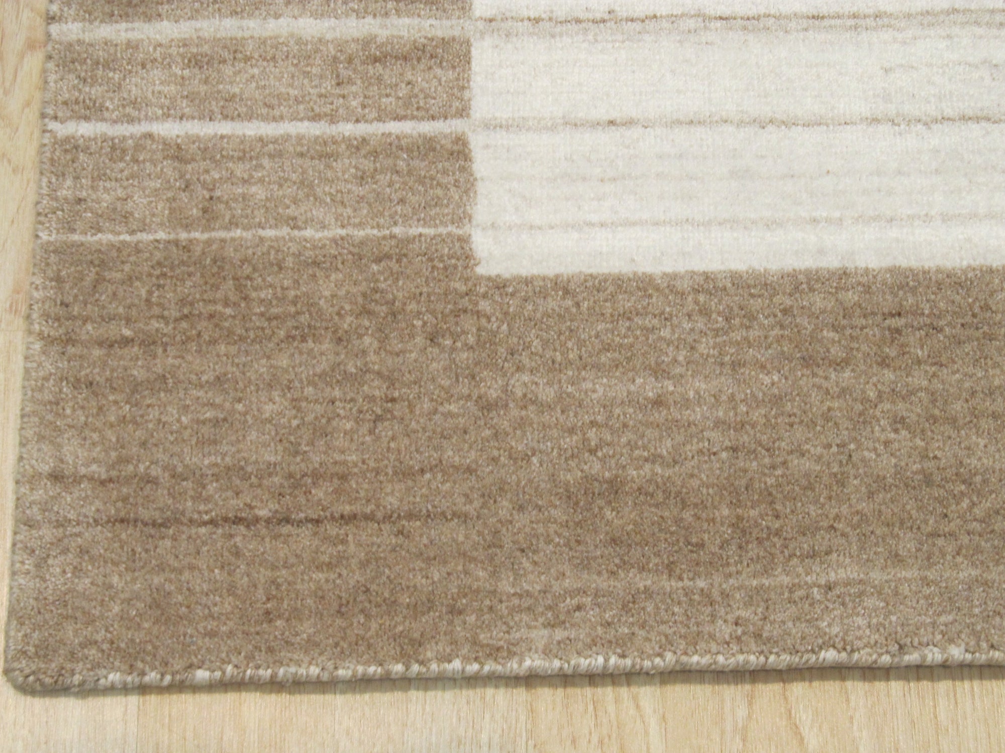 Rhea Quinn Brown Handmade Wool & Viscose Rug, blending warm brown tones and subtle textures, displayed in a cozy living room setting with contemporary furniture, highlighting its soft sheen and handcrafted quality.