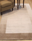 Rhea Quinn Brown Handmade Wool & Viscose Rug, blending warm browns in a subtly textured design, lies invitingly on a light hardwood floor, adding depth and organic elegance to the space.