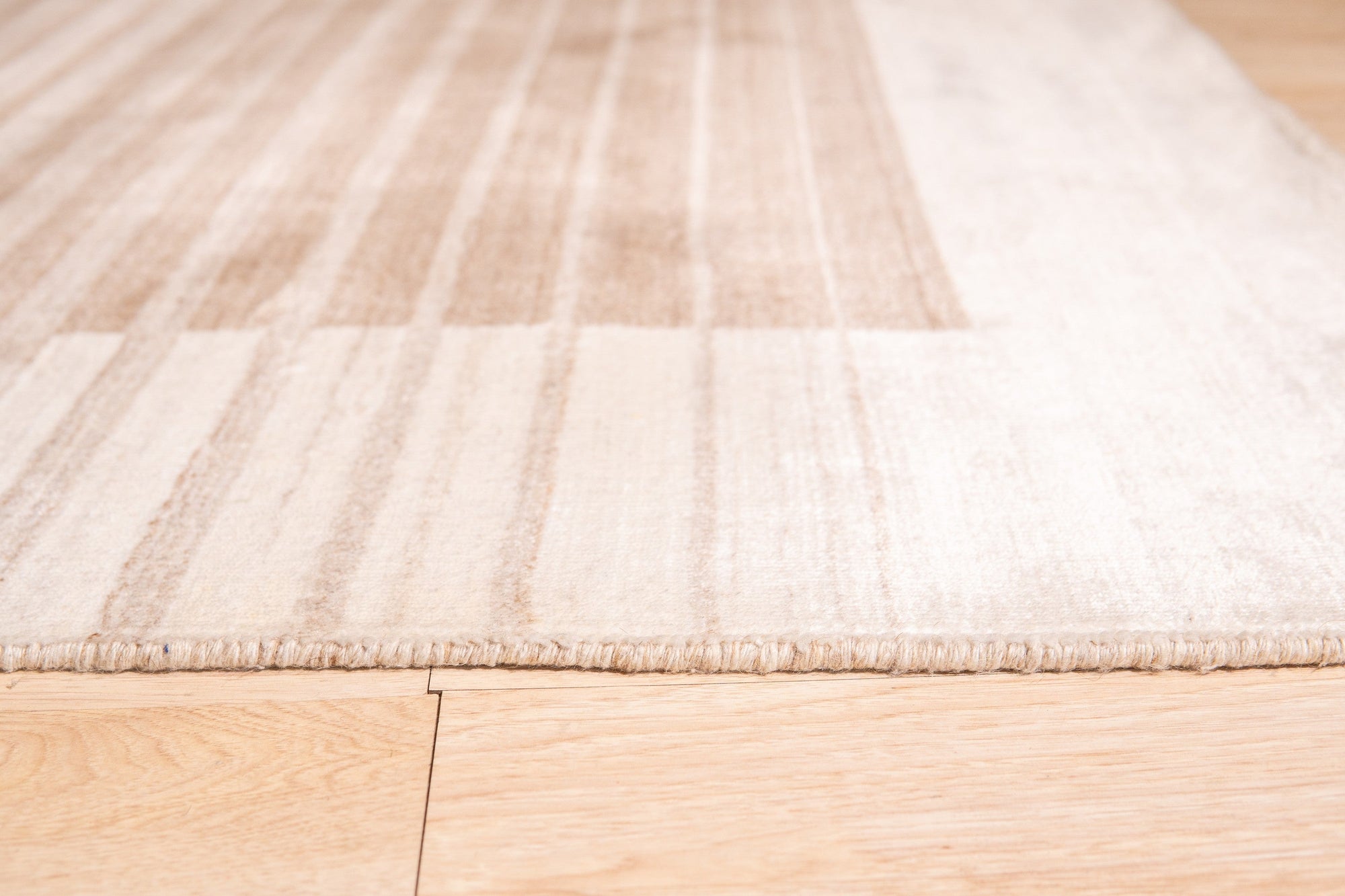 Rhea Quinn Brown Handmade Wool & Viscose Rug, boasting a textured, subtly patterned design in warm brown tones, displayed in a bright living space.