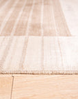 Rhea Quinn Brown Handmade Wool & Viscose Rug, boasting a textured, subtly patterned design in warm brown tones, displayed in a bright living space.