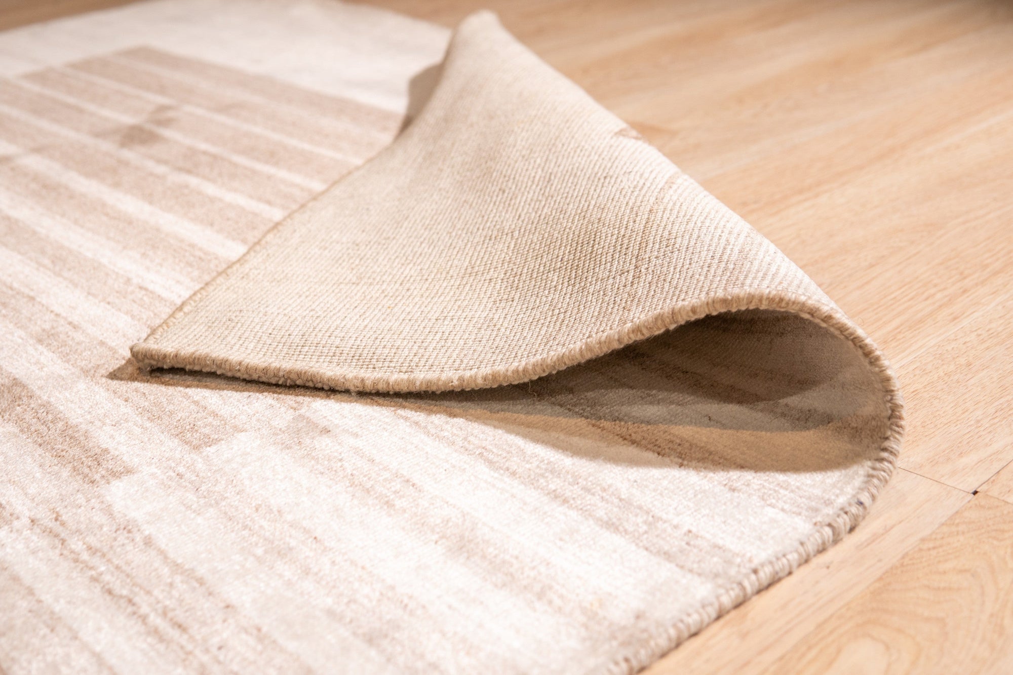 Rhea Quinn Brown Handmade Wool & Viscose Rug, displaying a textured, abstract pattern in warm browns and creams, adding a touch of modern sophistication to a bright, airy living space.