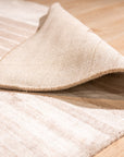 Rhea Quinn Brown Handmade Wool & Viscose Rug, displaying a textured, abstract pattern in warm browns and creams, adding a touch of modern sophistication to a bright, airy living space.