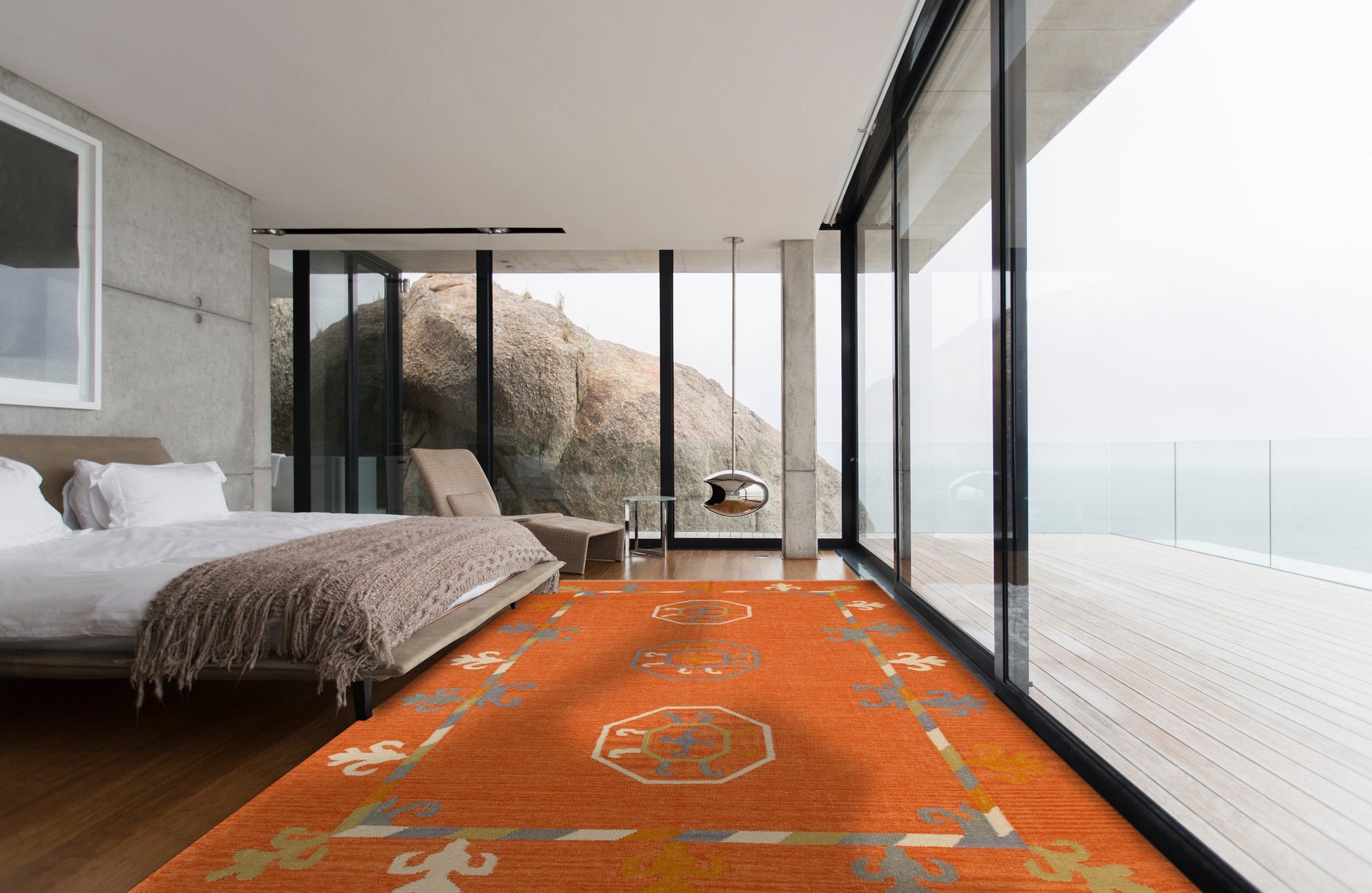 Maya Kilim Rust Flatweave Wool Rug, showing a detailed geometric pattern in warm rust and earth tones, laid on a light hardwood floor in a brightly lit room.