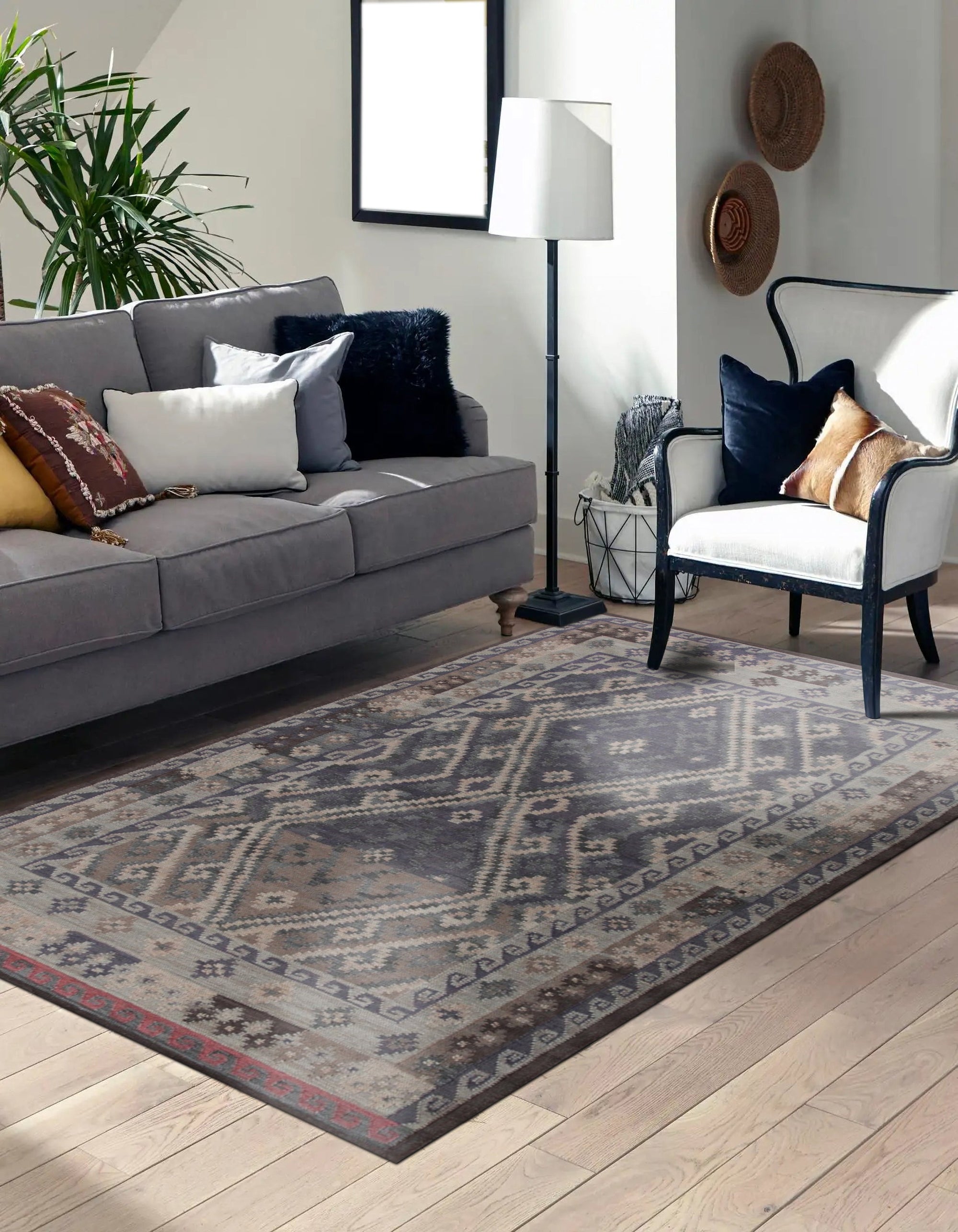 Brenda Jasmine Brown Flatweave Wool Rug graces a warmly lit living room; its intricate brown pattern and flatweave construction complement the neutral sofa and hardwood floors, creating a cozy and inviting space.