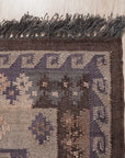 Brenda Jasmine Brown Flatweave Wool Rug, showcasing warm brown tones and a subtle geometric pattern in a well-lit living room setting, adding texture and warmth to the space.
