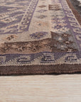 Brenda Jasmine Brown Flatweave Wool Rug, showcasing a warm, inviting design with intricate geometric patterns in varying shades of brown and beige, laid out in a bright living room setting.