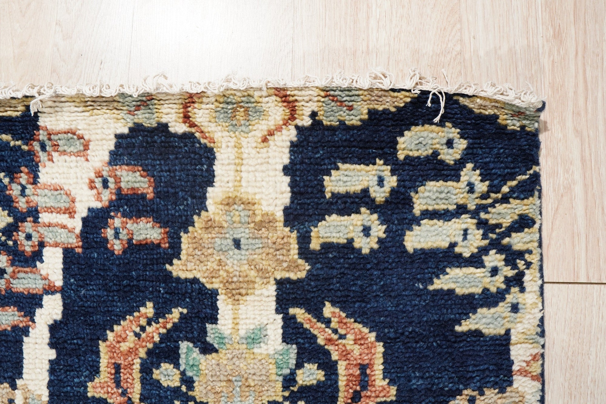Zinnia Louie Blue Hand Knotted Wool Rug, its intricate floral design blooming across a soft blue field, showcases the rug's texture and detail in a close-up view.