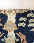 Zinnia Louie Blue Hand Knotted Wool Rug, its intricate floral design blooming across a soft blue field, showcases the rug's texture and detail in a close-up view.