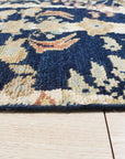 Zinnia Louie Blue Hand Knotted Wool Rug, a vibrant floral design rendered in cool blues and creams, showcasing the rug's texture and intricate knotwork.