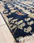 Zinnia Louie Blue Hand Knotted Wool Rug, showcasing its intricate hand-knotted construction and blue color palette, rests on a light floor, adding warmth and texture to a bright, modern living space.