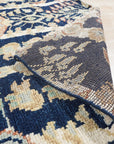 Zinnia Louie Blue Hand Knotted Wool Rug, its intricate floral pattern in shades of blue and cream gracing a light hardwood floor, lending a touch of elegant comfort to the room.