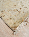 Nina Luxurious Ivory Hand Knotted Wool Rug, its plush ivory wool catching the light in a warmly lit room, hand-knotted texture visible in the close-up view.