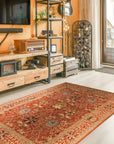 Lydia Vibrant Red Hand Tufted Wool Rug, a fiery red wool rug with a geometric pattern, anchoring a contemporary living room with a gray sofa and warm wood accents.