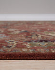 Lydia Vibrant Red Hand Tufted Wool Rug, bold red wool rug with a textured, abstract design, partially visible under a modern coffee table on a light wood floor.
