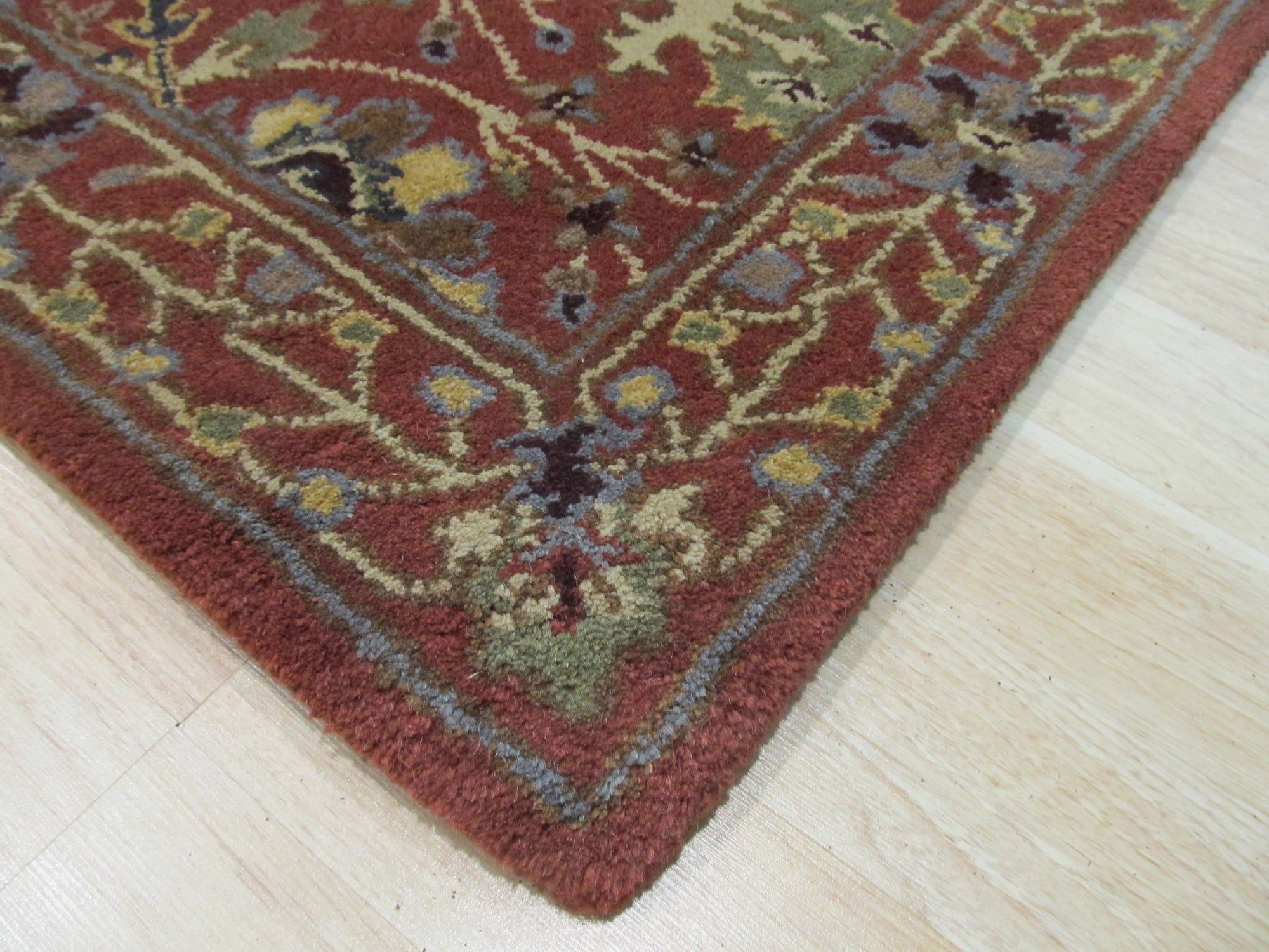 Lydia Vibrant Red Hand Tufted Wool Rug, displaying a warm and inviting splash of red. Hand-tufted construction highlights the texture and depth of the wool fibers, creating a plush, luxurious feel underfoot. The rug is seen in a bright, modern living space, complementing the neutral-toned furniture.