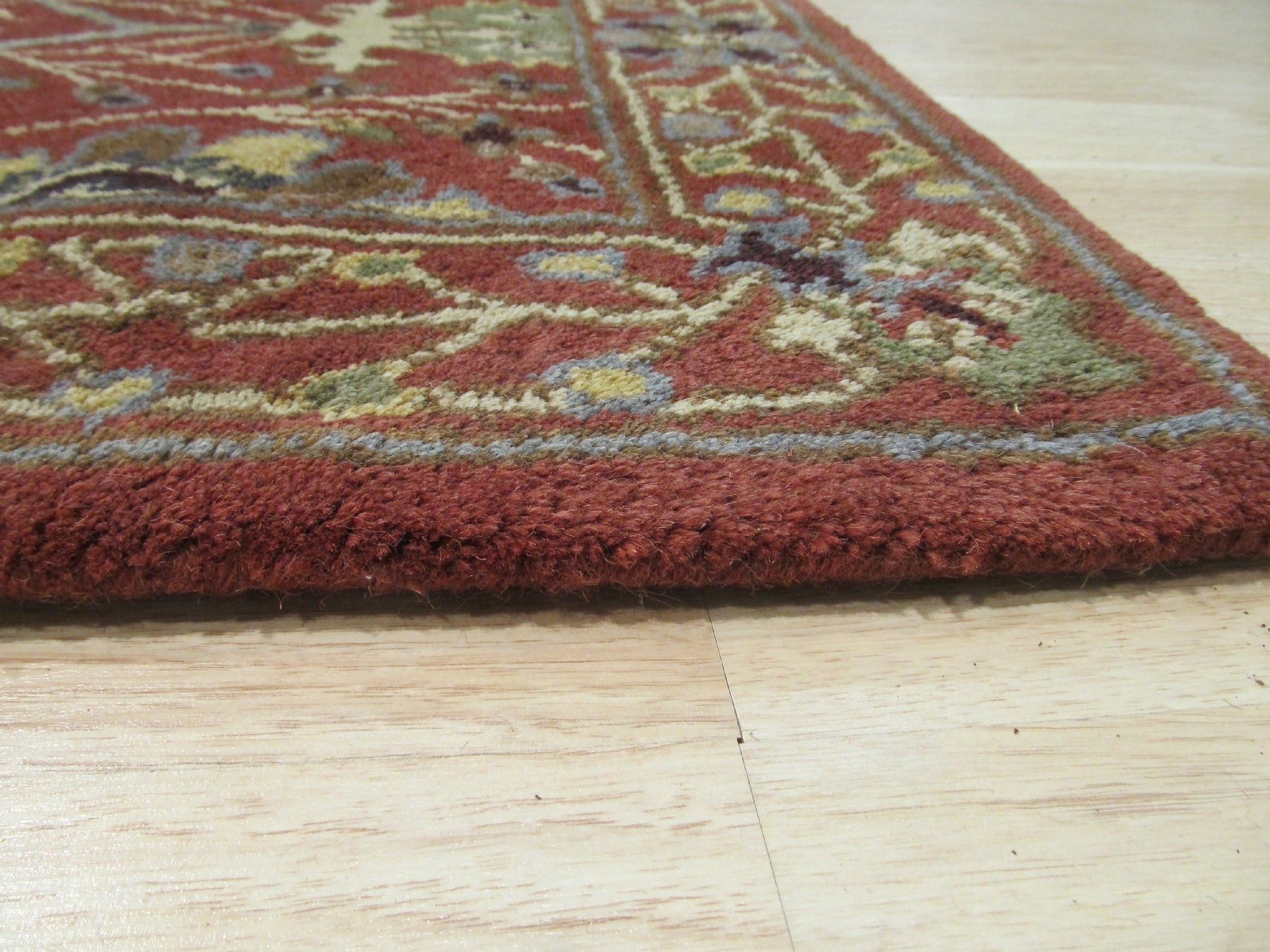 Lydia Vibrant Red Hand Tufted Wool Rug displayed in a modern living room setting. Warm red hues and soft wool texture complement a light-filled space, showcasing the rug's hand-tufted construction and adding a vibrant focal point to the décor.