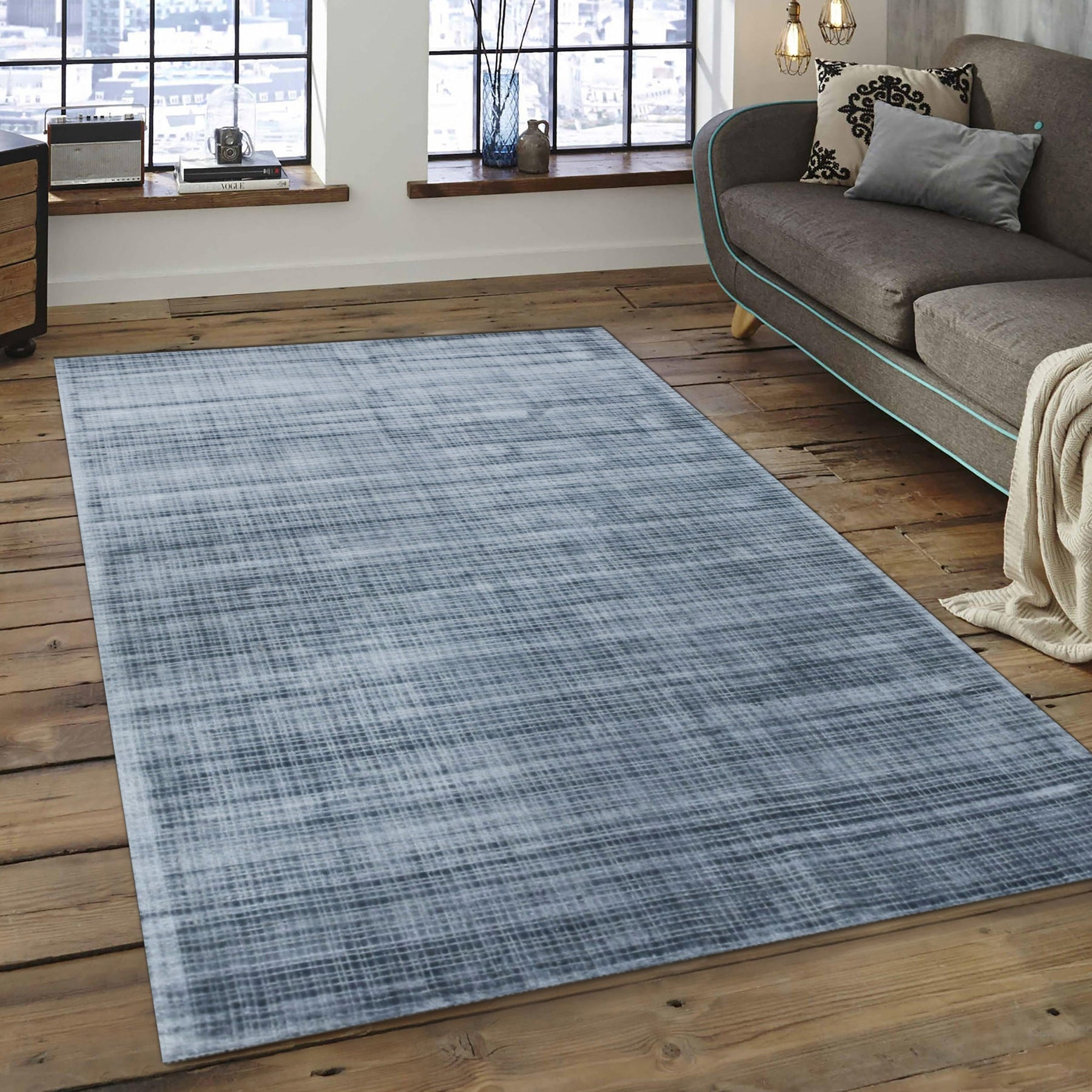 Captivating Lush Blue Handmade Rug, displaying deep blues with subtle texture variations, lies on a light wood floor, adding warmth and depth to a modern space.